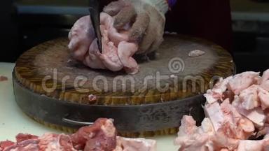 慢动手的猪肉店老板使用刀切生肉在木板上。